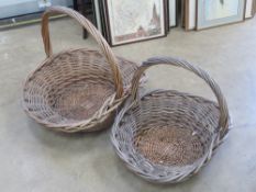 A pair of graduated wicker flower baskets with loop handles, largest 69 x 59 x 59cm.
