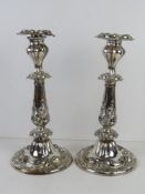 A pair of silver plated candlesticks having profuse repoussé decoration throughout and removable