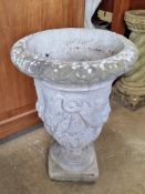 A pre-cast stone planter decorated with swags, 58cm high.
