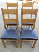 A set of four contemporary oak chairs having leatherette seats.