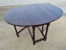 A oak drop leaf gate leg table, barleytwist legs, 135.5 x 105cm ext.
