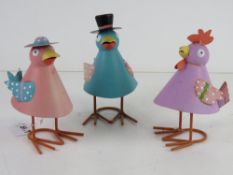 Three colourful metal chicken sculptures.