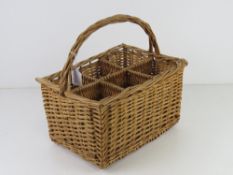 A wicker wine bottle holder having six sections and loop handle, 35 x 24cm.