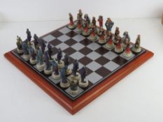 A hand painted good versus evil chess set in original packaging.