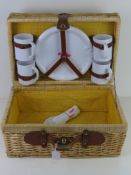 A Joosters picnic hamper having plastic plates etc within.
