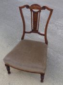 A green upholstered low fireside chair.