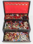 A leatherette jewellery box containing a quantity of assorted costume jewellery.