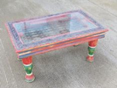 A colourfully painted Indian style coffee table having iron work centre with glass top, 94 x 57.
