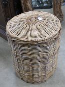 A large wickerwork lidded laundry hamper 53cm diameter.