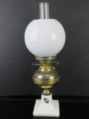 An oil lamp having ceramic base with brass reservoir marked for Duplex,