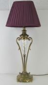 A brass and cut glass table lamp, with purple shade, all standing 72cm high.