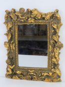 A small contemporary wall mirror having cherub and acanthus leaf design to frame all measuring 22 x