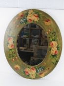 A contemporary oval wall mirror having floral decoration upon 60 x 70cm overall