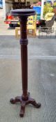 A mahogany torchere standing 139cm high.