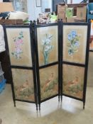 An antique three fold screen having three hand painted silk flower panels above three printed