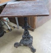 A cast iron based pub table raised over 3 outswept feet with double fish design column and wooden