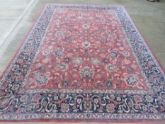 A 100% wool rug in red and navy ground having floral pattern,