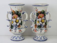 A pair of white ground continental style vases having floral decoration upon and each standing 32.