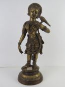 A heavy brass figurine of a South Asian goddess with bird on hand standing 51cm high