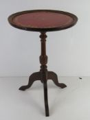 A red leather topped occasional or wine table.