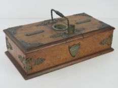 An oak desktop cigars and cigarettes box having shield to front with cigar cutter over, 29cm wide.