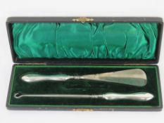 A boxed HM silver handled button hook and shoe horn, one item deficient.