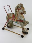 A vintage tin plate child's walker in the form of a show ground pony.