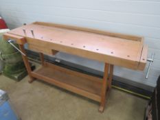 A contemporary workbench having central drawer and two integral vices.