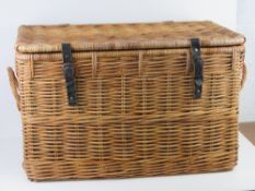 A large coffee table sized lidded wicker hamper having end handles and leather straps approx 72 x