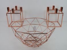 A rose metal fruit bowl and pair of geometric candle sconces. Three items.
