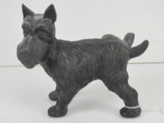 A cast iron doorstop figurine of a dog cocking its leg.