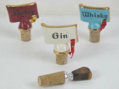 Three vintage ceramic and cork bottle stoppers together with a contemporary bottle stopper having