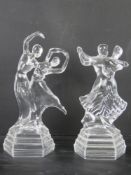 A pair of decorative glass daner figurines.