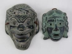 Two terracotta Greek theatre masks, largest 13.3cm in length.