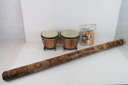 A didgeridoo with applied red, green, yellow and white dot decoration, 121cm in length.