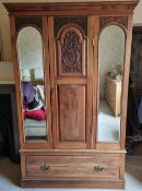 An Edwardian mirror front wardrobe having machine carved decoration, 123 x 46 x 197cm.