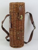 A wicker wine bottle carrier / picnic ha