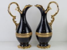 A pair of Limoges cobalt blue ground and 22 carat gold plated ewers each standing 37.