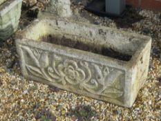 A pre-cast stone planter having tulip and rose decoration upon, 61cm wide.