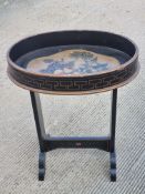 A hand painted and ebonised oval occasional table, 50 x 32cm approx.