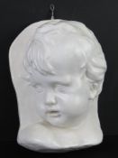 A white painted plaster wall plaque of a cherubic child, 25cm high.