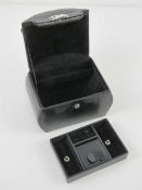 A contemporary black leather jewellery case having various compartments within. 15 x 10.5 x 21cm.