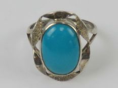 A silver and turquoise cocktail ring having brushed and polished pierced gallery around the oval