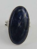 A Scottish hallmark silver blue hardstone agate ring, central cabachon approx 32 x 16mm, size Q.