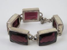 A five panel bracelet each set with faceted garnet coloured paste, no apparent hallmarks,