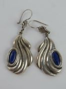 A pair of handmade lapis lazuli earrings having designer name to back, designer indistinct,