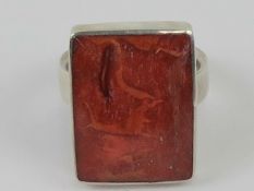 A contemporary silver and faux coral ring, stamped 925, size M.