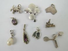 A quantity of silver and white metal charms and pendants including; cat with ball,