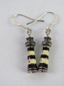 A pair of enamelled earrings in the form of lighthouses.