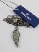 A Swarovski crystal angel wing design pendant on chain in original presentation box.